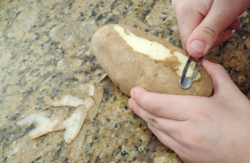 Young boy peeling potato