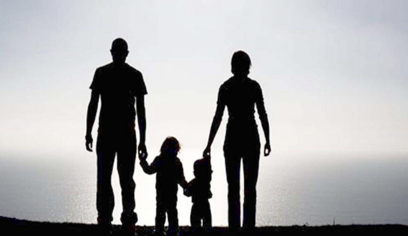 Crisis Mode - Parents with two children holding hands in silhouette