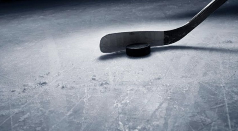 Hockey stick and puck on the ice - minor hockey
