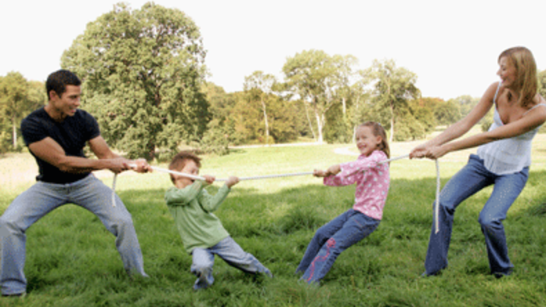 Mother Father and two children playing tug of war