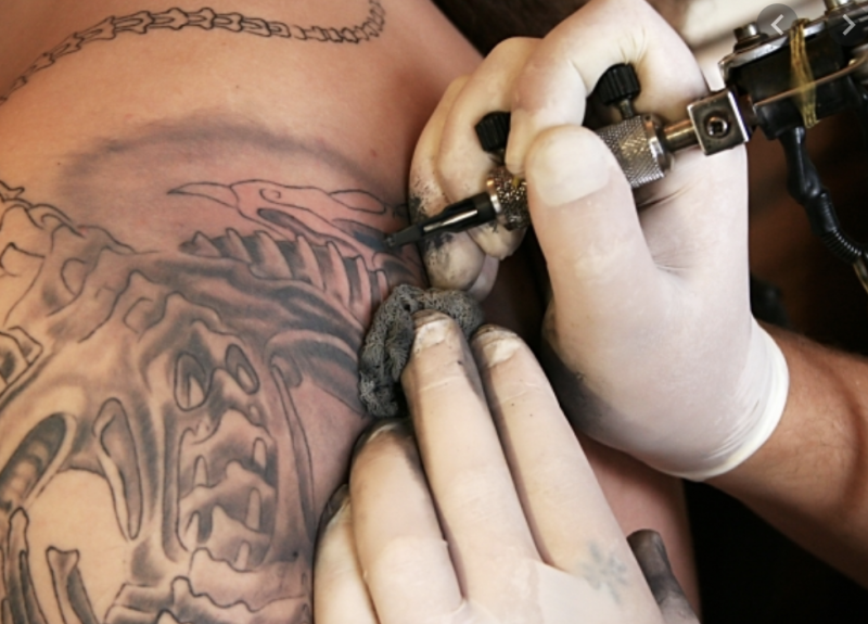 Tattoo artist applying artwork