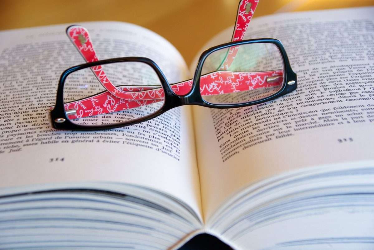 Open book with reading glasses on top