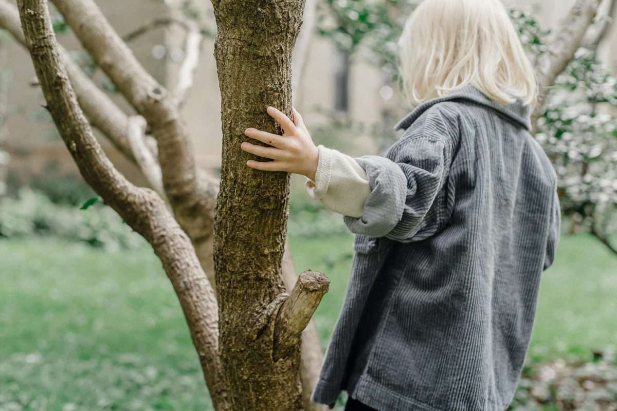young girl holding a tree branch