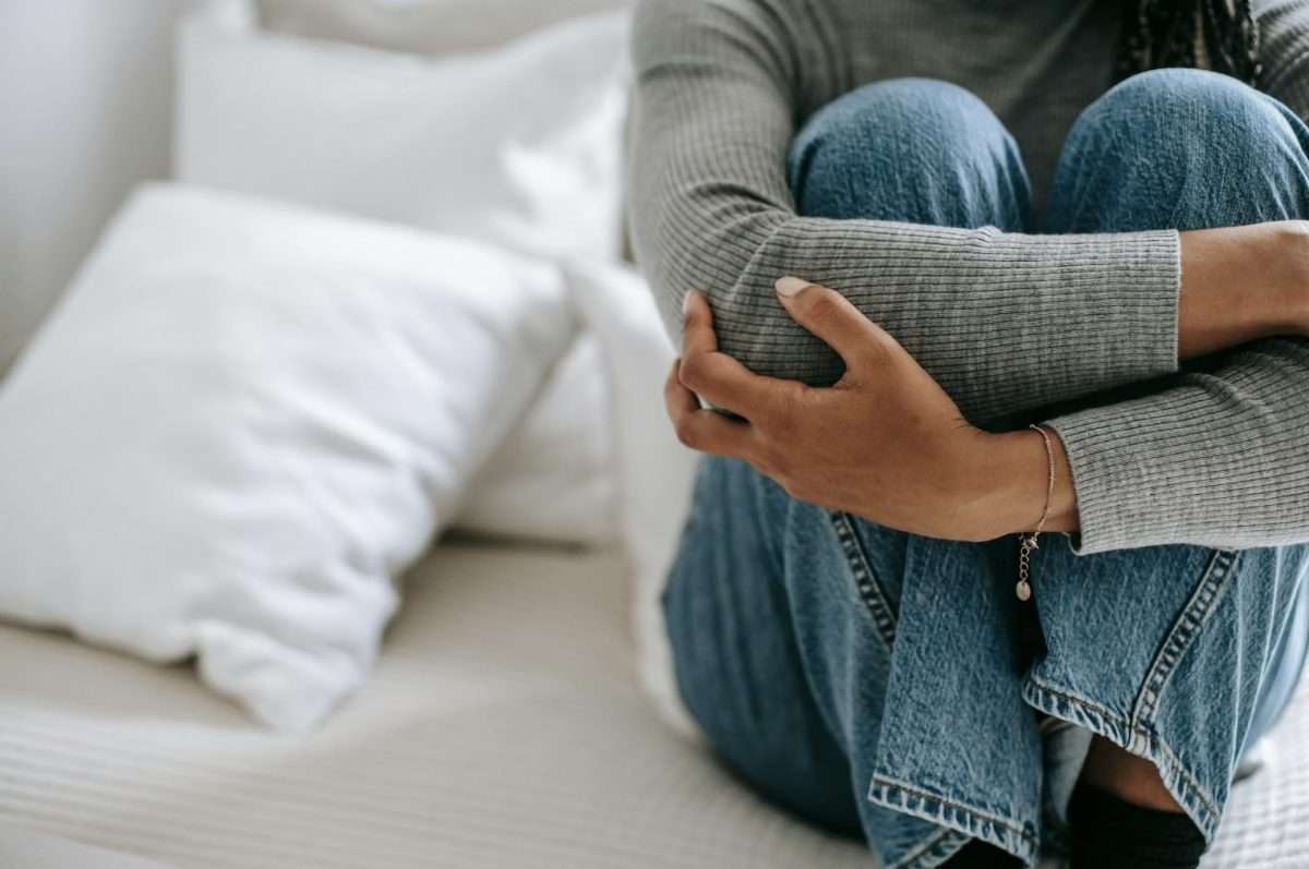 Girl on bed holding herself