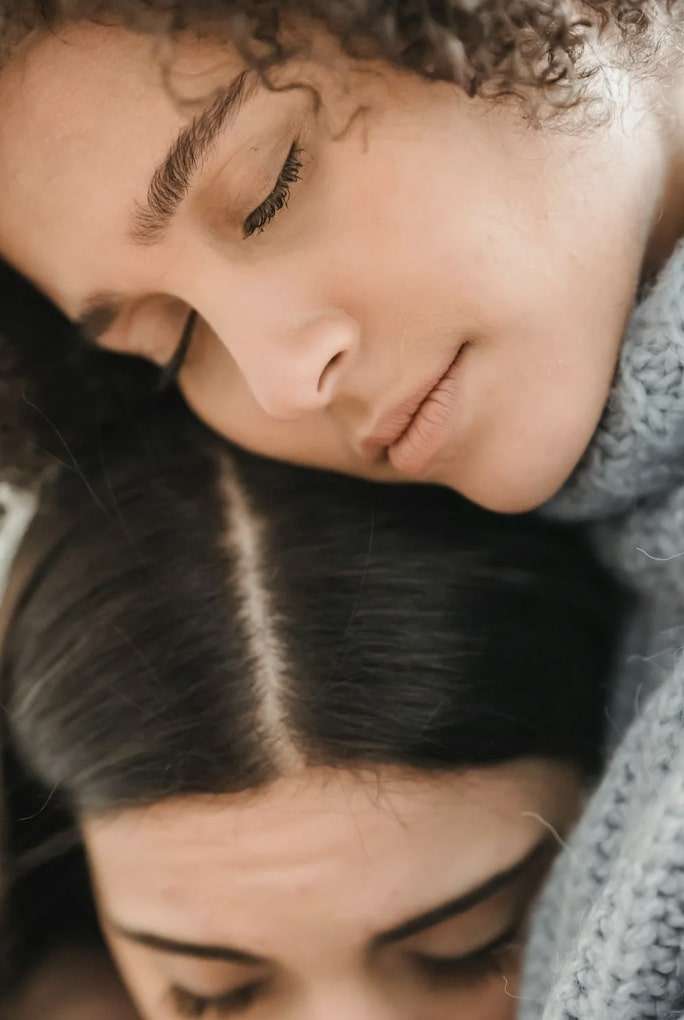 Woman and child eyes closed embracing