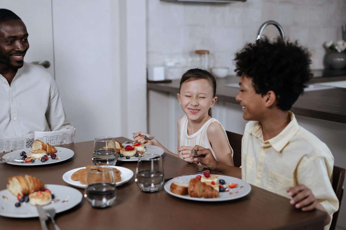parent and siblings laughing at mealtime