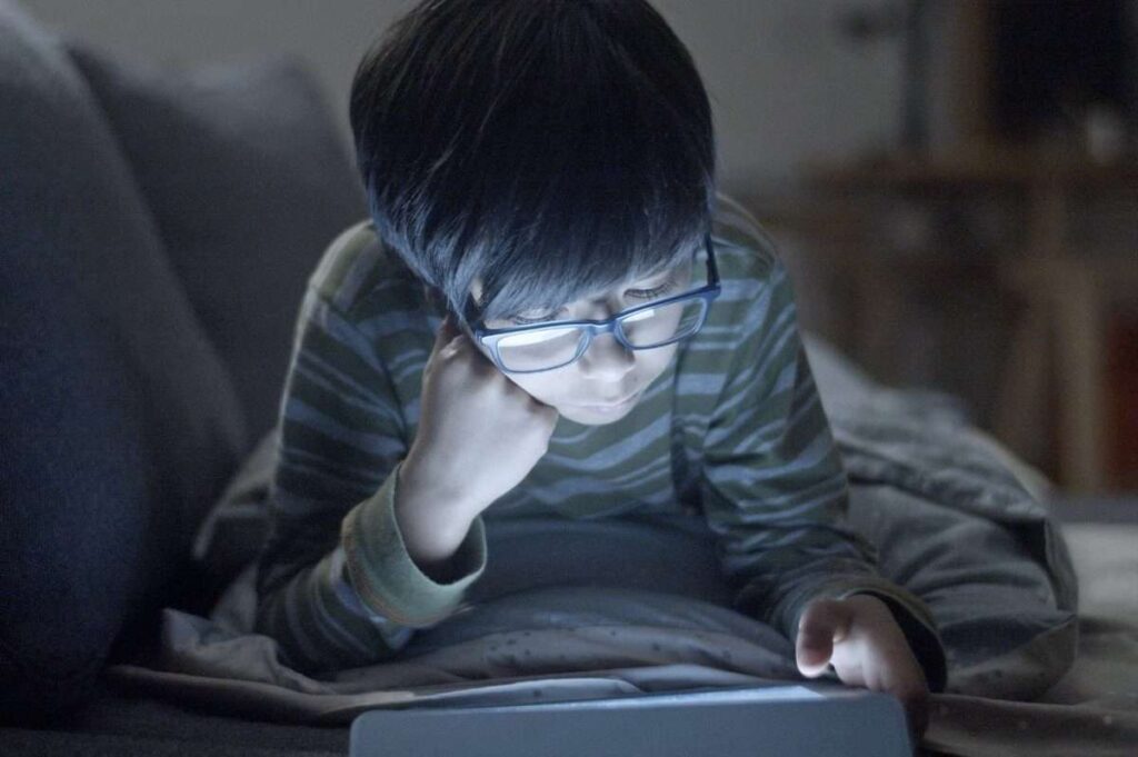 Boy with glasses on device