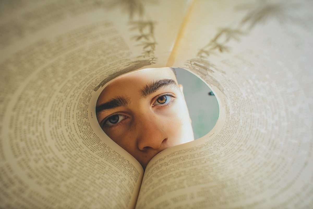 teen boy looking through book
