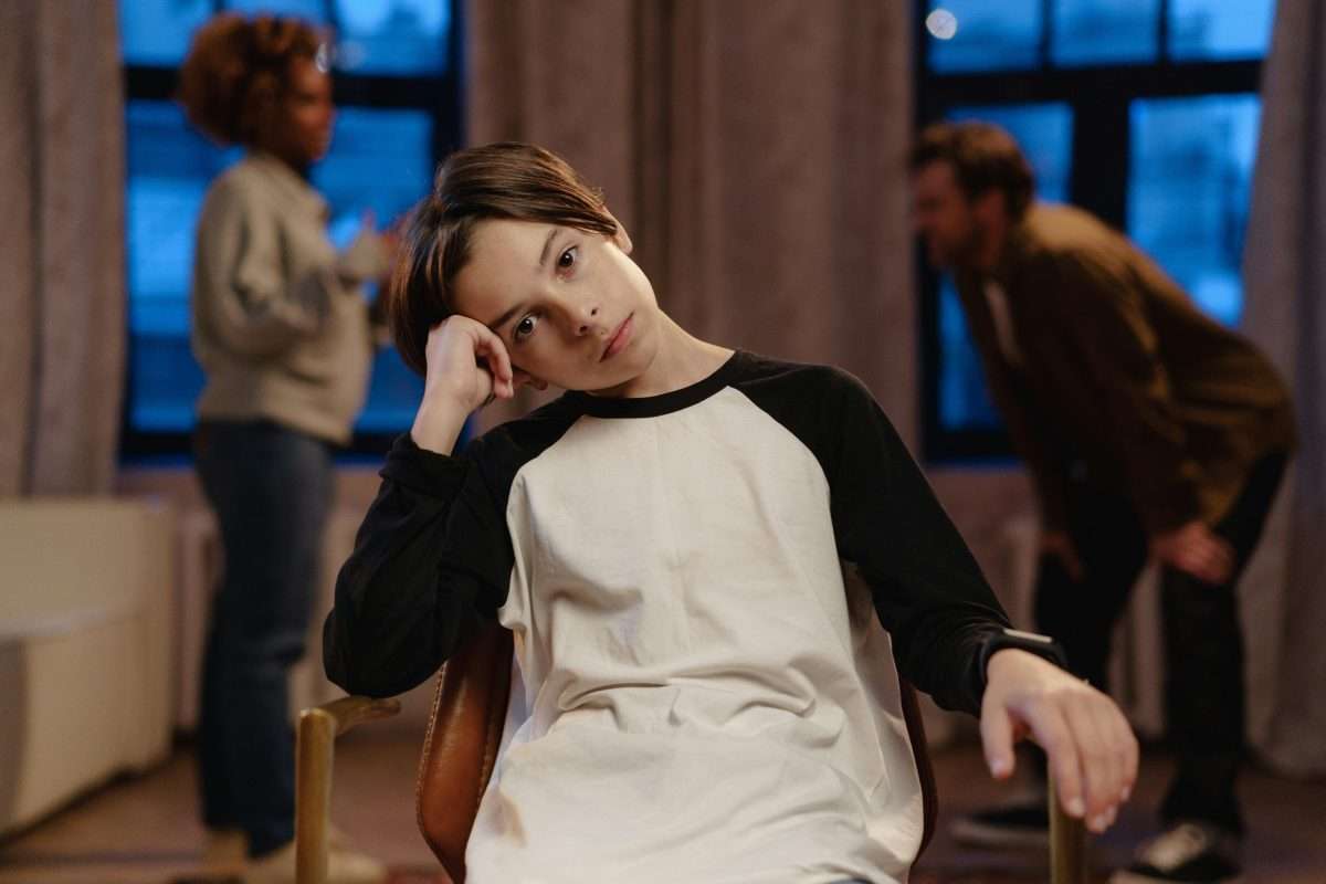 sad tween boy sitting on chair looking to camera