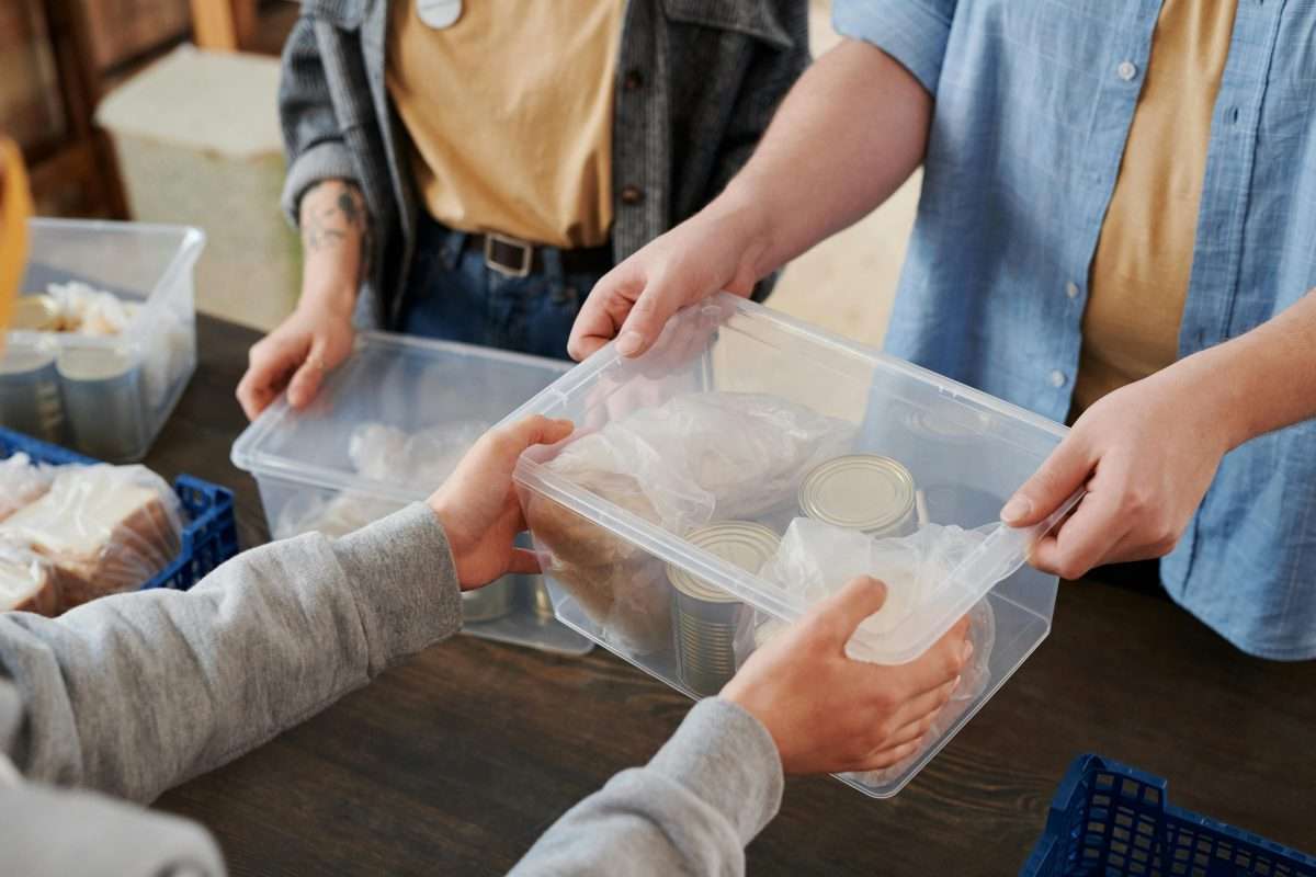 A Person Handing Over a Box with Food 