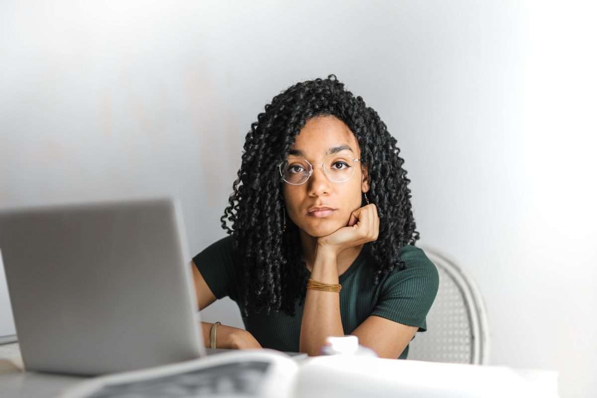 Serious ethnic young woman using laptop at home