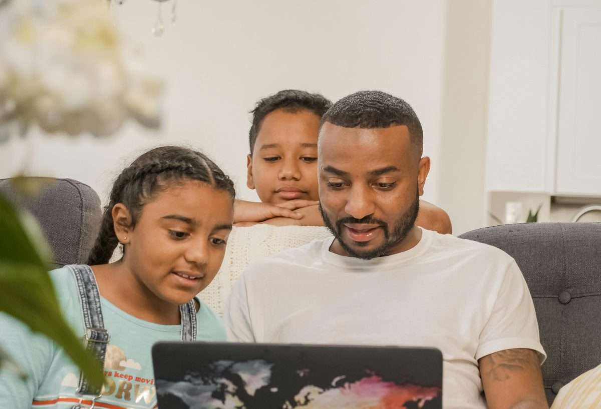 Man and Children Looking at the Laptop