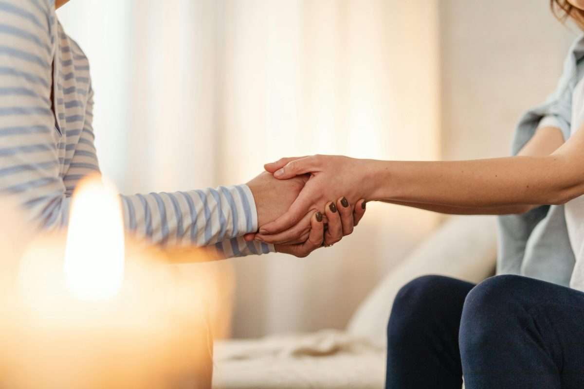 Close Up Photo of People Holding Hands